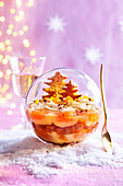 Weihnachtliches Clementinen-Trifle serviert in Schneekugel
