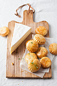 Mini-Scones und ein Stück Brie auf Holzbrett