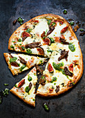 Pizza with cheese, mushrooms, figs and pesto