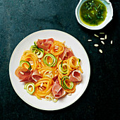 Spaghetti of carrot and zucchini with raw ham and herb sauce