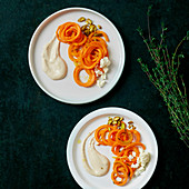 Carrot spaghetti with feta and pistachios and hummus sauce