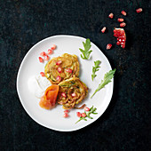 Zucchini spaghetti fritter with smoked salmon and pomegranate seeds