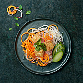 Vegetable spaghetti made with carrots, radish and cucumber with fried tofu