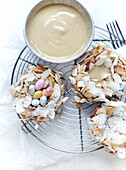 Easter nest with coconut, flaked almonds and sugared eggs served with white chocolate sauce