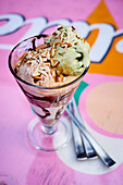 Ice cream sundae with pistachio and chocolate ice cream and roasted almond slivers