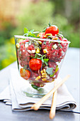 Tartar balls with cherry tomatoes, pine nuts and herbs in a jar