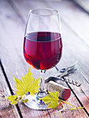 A glass of red wine on a wooden base