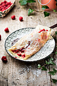 Crêpe with raspberries and icing sugar