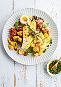 Roasted cabbage with patatas bravas with tomato sauce and hard-boiled egg