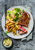 Grilled beef steak with bearnaise sauce served with chips and salad