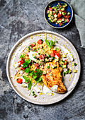 Chicken fillet on couscous salad with tomatoes and cucumber