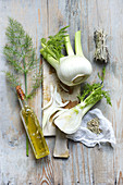 Still life with fresh fennel, fennel seeds, olive oil flavoured with fennel seeds and fennel herb