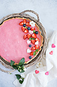 Strawberry mousse cake decorated with berries and sugar hearts