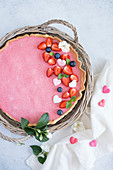 Erdbeermoussetorte dekoriert mit Beeren und Zuckerherzen