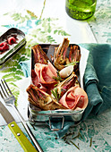 Grilled artichokes with raw ham in a bread box
