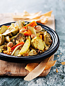 Vegetable tagine with round courgettes, artichokes, carrots, fennel and olives