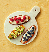 Roasted sweet potato slices topped with raspberries, avocado and blueberries