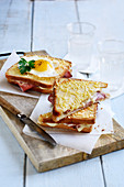 Croque-monsieur et croque-madame, ham and cheese toasted sandwiches and one topped with a fried egg