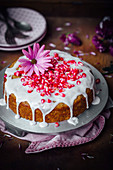 Egg free banana and coconut cake decorated with sugar icing and pomegranate seeds