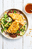 Baked white cabbage on red rice with cucumber salad and apple sticks