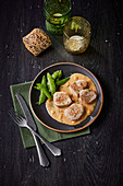 Veal medallions with cream sauce and pea pods
