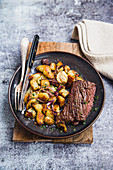 Gegrilltes Onglet-Steak mit Bratkartoffeln und Zwiebeln