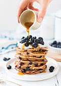 A stack of blueberry pancakes with honey