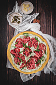 Pizza mit Salami, Kapern und Rucola
