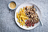 Steak, French fries and mushrooms with pepper sauce