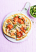 Pizza mit Räucherlachs, Tomaten, Pilzen und Kräuterfrischkäse