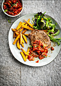 Steak with spicy tomato sauce and french fries