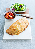 Calzone with ham, spinach and tomato filling