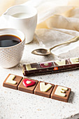 Belgische Milchschokolade mit der Aufschrift 'love' zur Tasse Kaffee