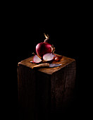 Rote Zwiebel mit Messer auf Holzblock