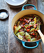 Pan-fried broad bean pods with tomatoes and raw ham