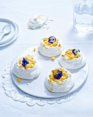 Mini pavlovas with mango, passion fruit and edible pansy flowers