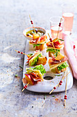 Aperitif skewers with speck, emmental cheese, peach and crouton