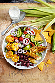 Mexikanischer Salat mit Hähnchen, Mais, Tomaten, Zwiebeln und Bohnen