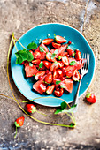 Red salad with watermelon, strawberries, tomatoes, currants and honey