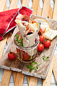 Aperitif jar : white bread cone garnished with raw ham,smoked scamorza,basil,olive and seeds
