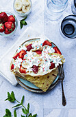 Crêpe garnished with banana,strawberry and whipped cream