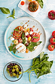 Salat aus Tomaten, Melone, Mozzarella mit Olivensauce und Basilikum