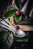 Still life with vintage spoons, blackberries and books