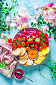 Crackers, summer vegetables, summer fruit and beetroot dip on a plate as an aperitif