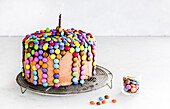 Gravity cake with colorful chocolate beans
