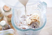 Milchshake mit Vanille zubereiten: Zutaten in Glasgefäß eines Standmixers geben