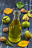 Bottle of vegetal oil surrounded with walnuts