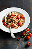 Fregola cooked in broth with prawns, cherry tomatoes and saffron