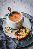 Cup of hot chocolate with a piece of marble cake