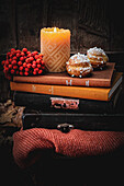 Chouquettes with a candle and berries on a stack of books
